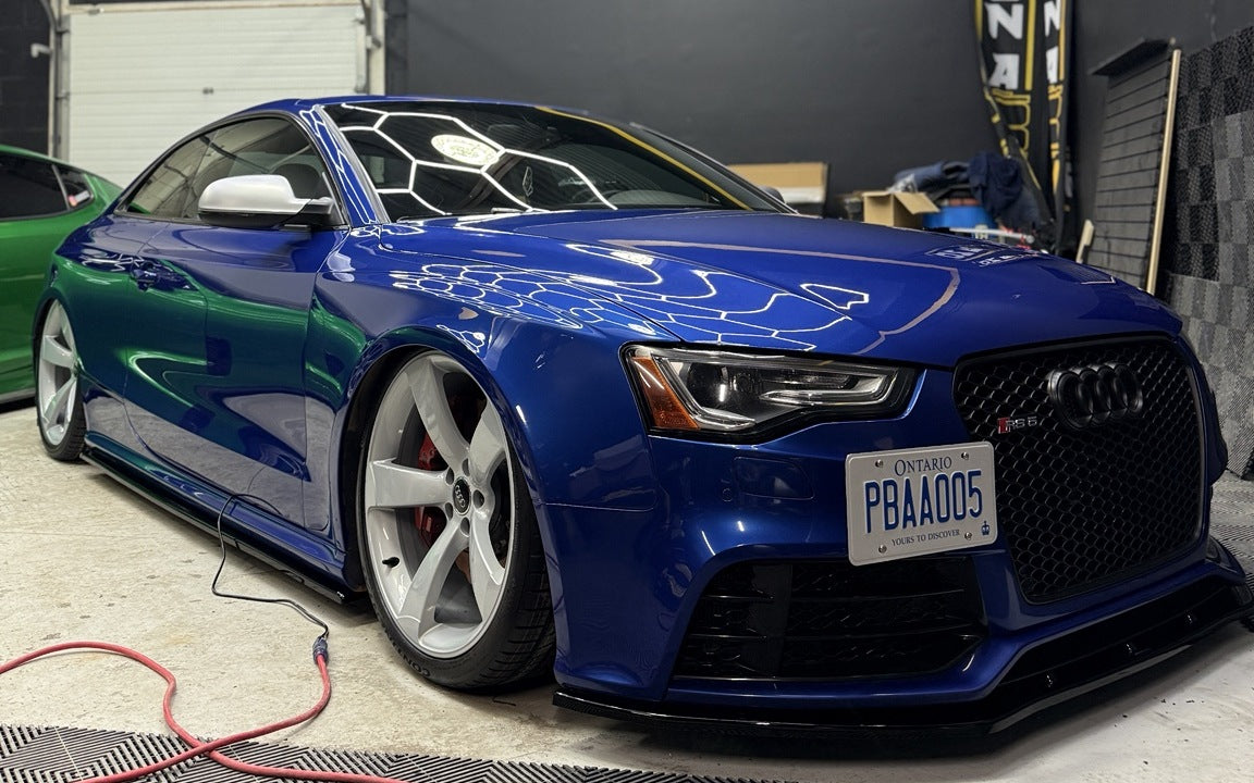 Blue Audi RS5 aired out on ONAIR air suspension with silver five-spoke wheels inside the ONAIR workshop.
