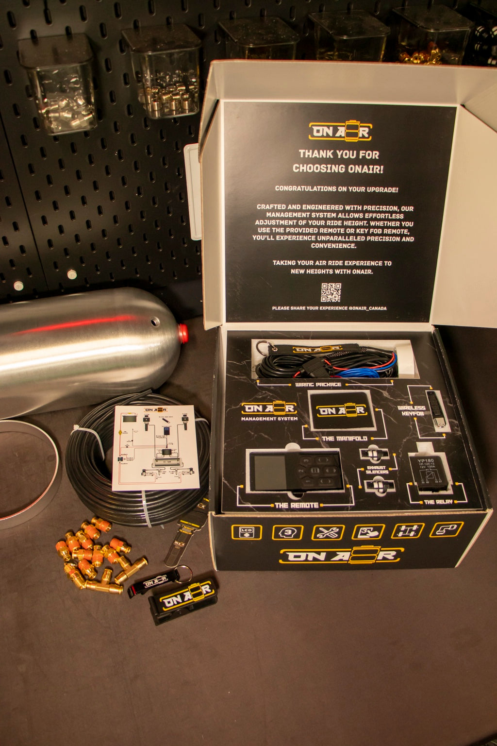 Image of Actual ONAIR 2V management packaging with controller, manifold, slim wireless key fob, wiring harness, relay and exhaust silencers