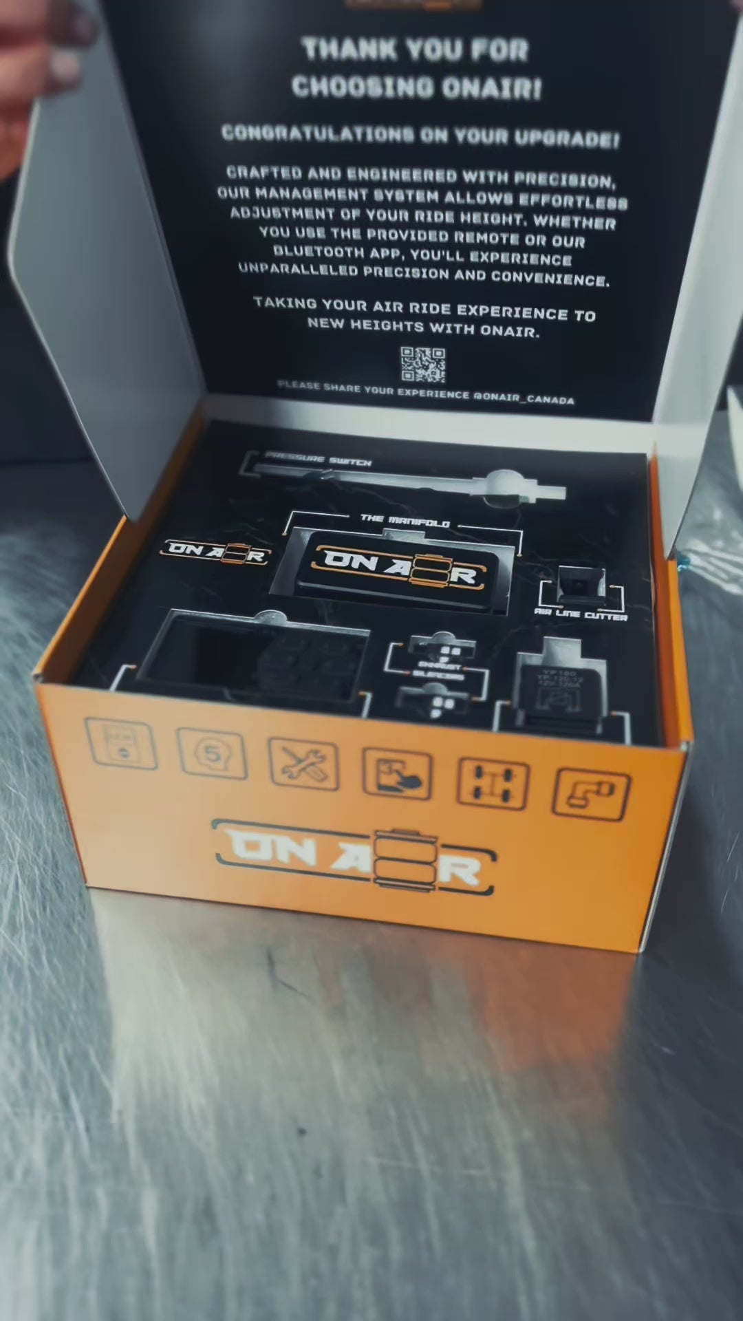 Image of ONAIR 4V Management System and packaging, remote controller, full set of mk4 air suspension, featuring red top hats, gold collar rings on the air bags. Lots of onair merch including the boxes and packaging such as air freshners, tshirts, hat, slick air tank.